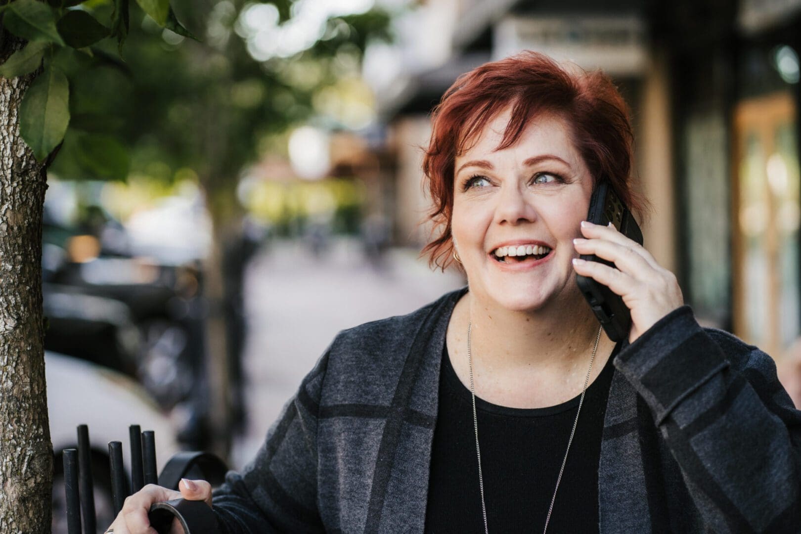 Smiling person talking on phone outdoors